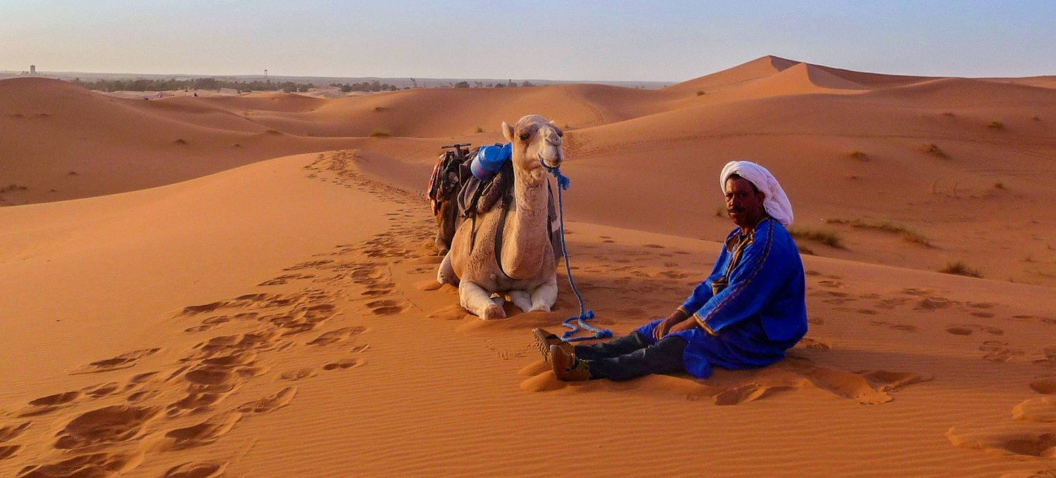 Mann mit Kamel in der Wüste Marokkos